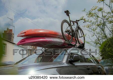 Stock Image - Car with surfboards and bicycle on roof rack. Fotosearch