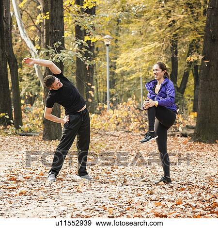 Stock Photo - Cheerful couple stretching after jogging. Fotosearch