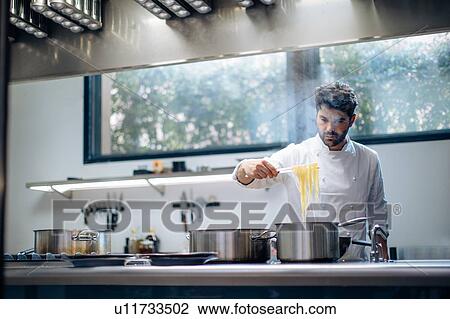 Chef cooking pasta in kitchen View Large Photo Image Stock Image - Chef cooking pasta in kitchen. Fotosearch