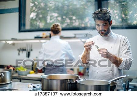Stock Photo - Chefs cooking with herbs in kitchen. Fotosearch