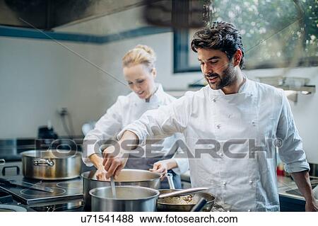 Stock Photo - Chefs stirring pots in kitchen. Fotosearch