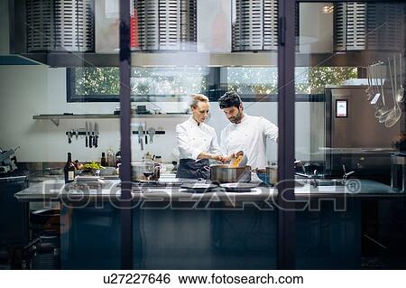 Stock Photograph - Chefs working together in kitchen. Fotosearch
