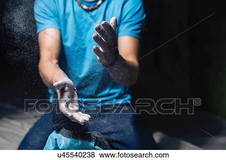 Stock Photo - Climber applying chalk on hands. Fotosearch