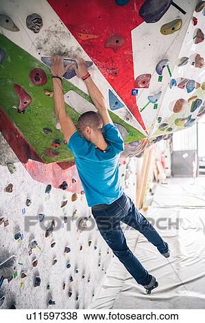 Climber dangling from climbing wall View Large Photo Image Stock Photo - Climber dangling from climbing wall. Fotosearch