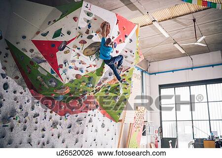Stock Photograph - Climber dangling from climbing wall. Fotosearch