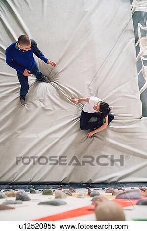 Stock Photography - Climber friends talking on crash mat. Fotosearch