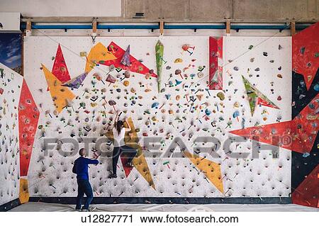Climber guiding friend on climbing wall View Large Photo Image Stock Image - Climber guiding friend on climbing wall. Fotosearch