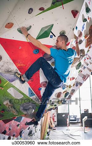 Stock Image - Climber on climbing wall. Fotosearch