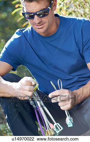 Stock Image - Climber preparing equipment. Fotosearch
