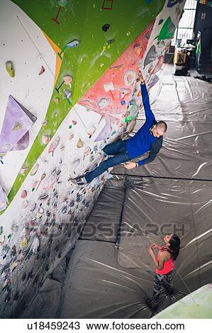 Climber watching friend on climbing wall View Large Photo Image Stock Image - Climber watching friend on climbing wall. Fotosearch