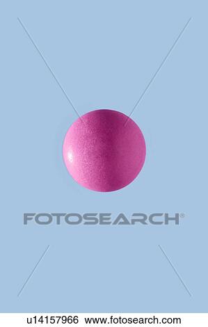 Stock Photograph - Close-up of one round pink pill. It contains Ibuprofen (iso-butyl-propanoic-phenolic acid) and is a non-steroidal anti-inflammatory drug (NSAID). It is taken as an analgesic (painkiller).. Fotosearch