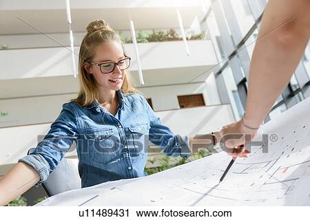 Stock Image - Colleagues brainstorming over charts in bright sunlight. Fotosearch