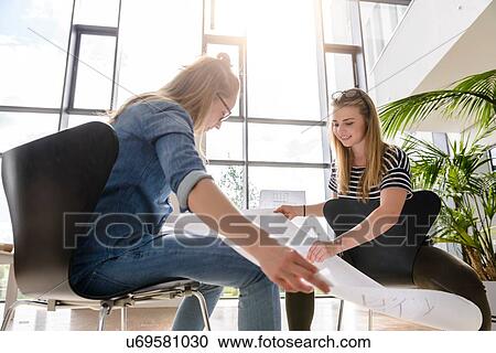 Stock Image - Colleagues brainstorming over charts in bright sunlight. Fotosearch