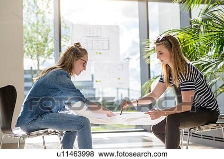 Colleagues brainstorming over charts in bright sunlight View Large Photo Image Stock Photo - Colleagues brainstorming over charts in bright sunlight. Fotosearch