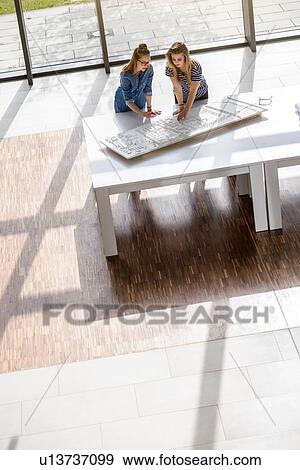 Colleagues brainstorming over architectural model View Large Photo Image Stock Photo - Colleagues brainstorming over architectural model. Fotosearch
