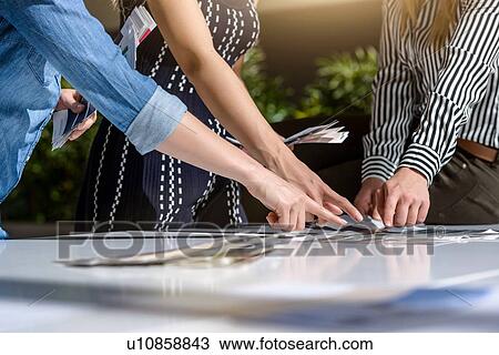 Stock Image - Colleagues brainstorming with colour charts. Fotosearch