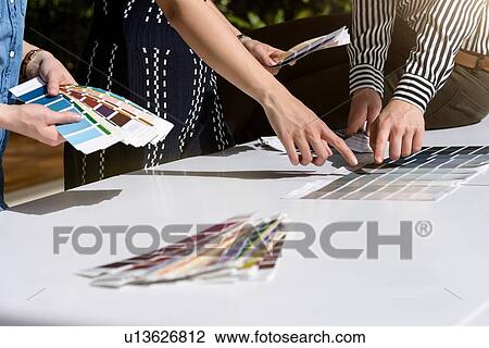 Stock Image - Colleagues brainstorming with colour charts. Fotosearch