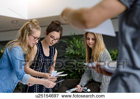Stock Photo - Colleagues brainstorming with colour charts. Fotosearch