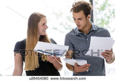 Stock Image - Colleagues discussing papers and project. Fotosearch