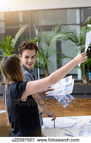 Stock Photo - Colleagues discussing papers and project. Fotosearch