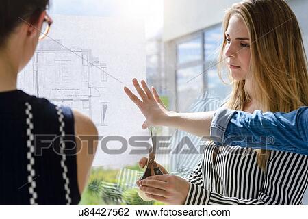 Colleagues discussing plans on glass wall View Large Photo Image Stock Image - Colleagues discussing plans on glass wall. Fotosearch