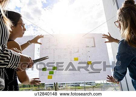 Colleagues discussing plans on glass wall View Large Photo Image Stock Photo - Colleagues discussing plans on glass wall. Fotosearch