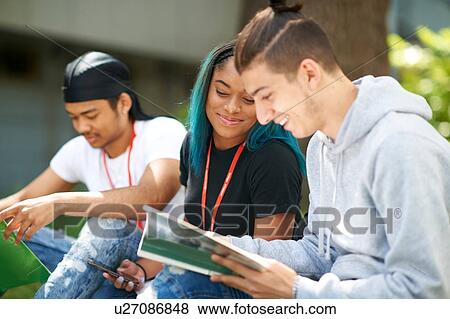 Stock Photo - College students reading and talking in campus. Fotosearch