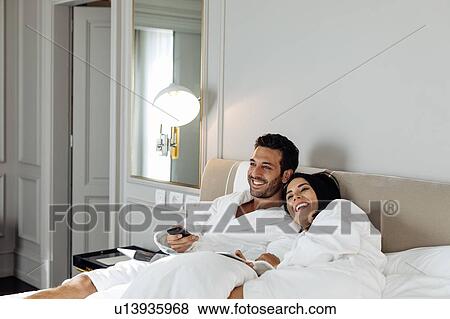 Stock Photo - Couple laughing and relaxing in suite. Fotosearch