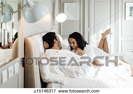 Couple laughing and relaxing in suite View Large Photo Image Stock Photo - Couple laughing and relaxing in suite. Fotosearch