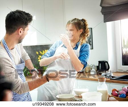 Stock Photo - Couple playing with flour in kitchen. Fotosearch