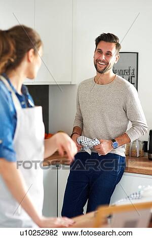 Stock Image - Couple talking in kitchen. Fotosearch