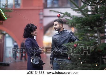 Stock Image - Couple window shopping at Christmas market, Freiburg, Baden-Wurttemberg, Germany. Fotosearch
