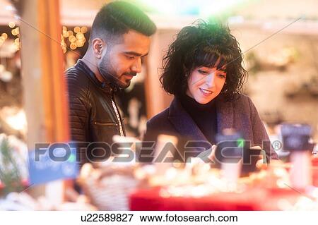 Couple window shopping at Christmas market, Freiburg, Baden-Wurttemberg, Germany View Large Photo Image Stock Photo - Couple window shopping at Christmas market, Freiburg, Baden-Wurttemberg, Germany. Fotosearch
