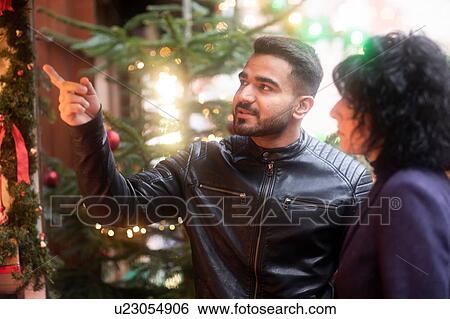 Stock Photograph - Couple window shopping at Christmas market, Freiburg, Baden-Wurttemberg, Germany. Fotosearch