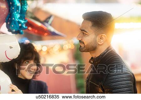 Stock Photography - Couple window shopping at Christmas market, Freiburg, Baden-Wurttemberg, Germany. Fotosearch