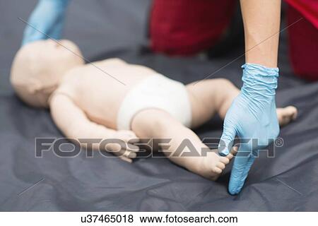Stock Photo - CPR training on baby dummy. Fotosearch