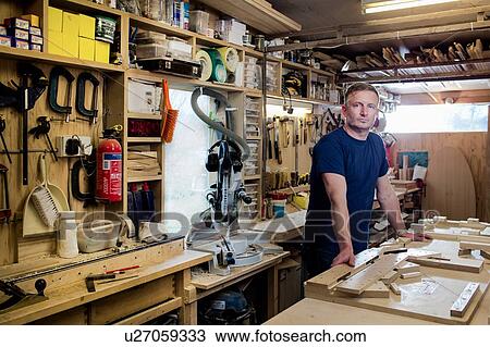 Stock Image - Craftsman beside his workbench and tools. Fotosearch