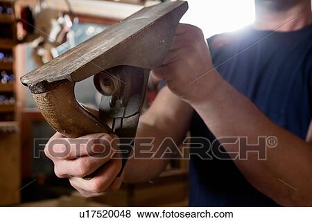 Craftsman holding wood plane in workshop View Large Photo Image Stock Photo - Craftsman holding wood plane in workshop. Fotosearch