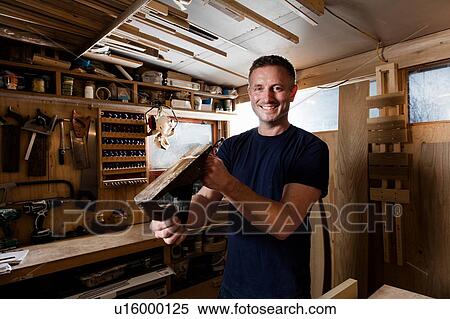 Craftsman holding wood plane in workshop View Large Photo Image Stock Photography - Craftsman holding wood plane in workshop. Fotosearch