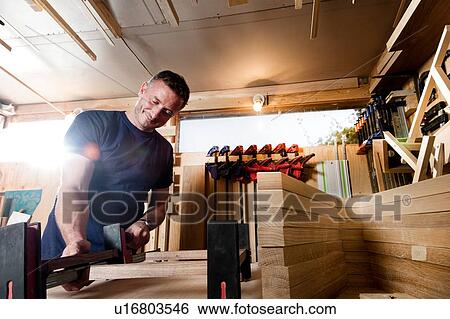 Stock Photograph - Craftsman preparing parts for wooden object. Fotosearch