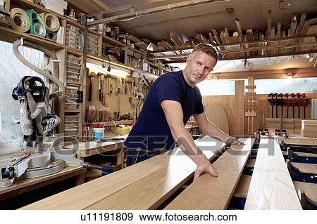 Craftsman preparing planks of wood in workshop View Large Photo Image Stock Photo - Craftsman preparing planks of wood in workshop. Fotosearch