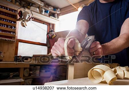 Craftsman using wood plane in workshop View Large Photo Image Stock Photo - Craftsman using wood plane in workshop. Fotosearch
