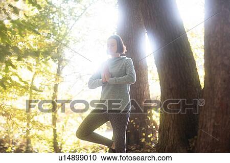 Cross country jogger practising yoga in park View Large Photo Image Stock Image - Cross country jogger practising yoga in park. Fotosearch