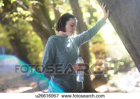 Stock Photo - Cross country jogger resting in park. Fotosearch