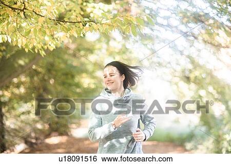 Cross country jogger running in park View Large Photo Image Stock Photograph - Cross country jogger running in park. Fotosearch
