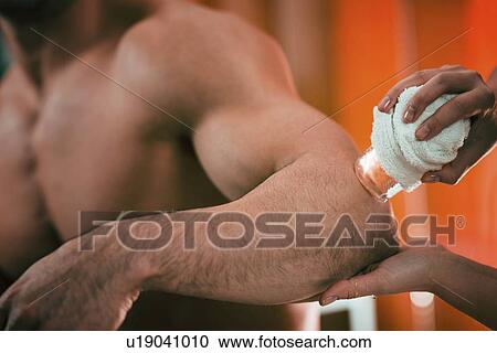 Stock Image - Cryo massage for elbow pain. Fotosearch