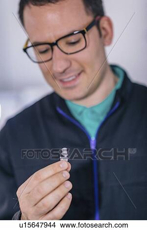 Picture - Dental technician holding prosthetic. Fotosearch