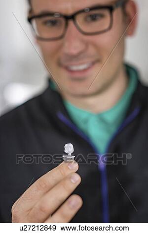 Stock Photo - Dental technician holding prosthetic. Fotosearch