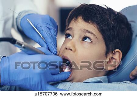 Stock Photograph - Dentist drilling young boy's tooth. Fotosearch