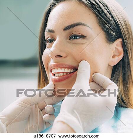 Stock Photo - Dentist inspecting woman's teeth. Fotosearch